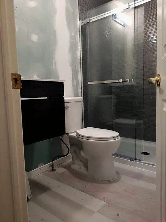 Finished bathroom with a floating vanity, toilet and glass shower